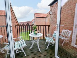 A balcony with a table and chairs at Berry Banks Cottage in Whitby
