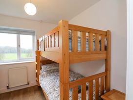 A bedroom with a bunk bed and window at Berry Banks Cottage in Whitby