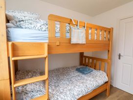 A bunk bed with bedding and a towel at Berry Banks Cottage in Whitby