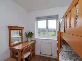 A bedroom with a bunk bed and a desk at Berry Banks Cottage in Whitby