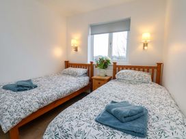 A bedroom with two single beds and a bedside table at Berry Banks Cottage in Whitby