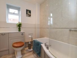 A bathroom with a bathtub and vanity unit at Berry Banks Cottage in Whitby