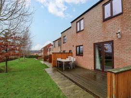 An outdoor patio area with table and chairs at Berry Banks Cottage Whitby
