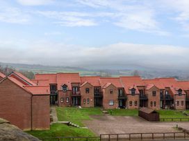 Buildings with red roofs and green areas at Berry Banks Cottage in Whitby