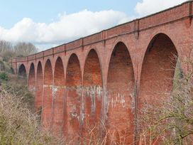 A brick viaduct with arches against a cloudy sky at an unknown location