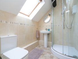 A bathroom with a toilet sink shower and skylight at Harrisons Cottage in Llandegla near Llangollen