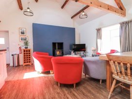 A living room with a sofa and television at Hen Blas Aberdaron