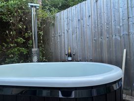 A hot tub with champagne bottles and glasses in an outdoor area at Treetops in Southerton near Sidmouth