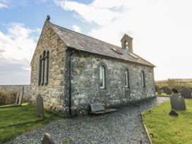 A stone church surrounded by gravestones at Eglwys St Cynfil in Penrhos near Pwllheli