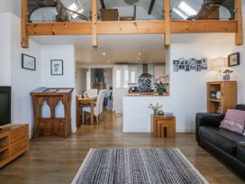 A living room with a sofa and dining area at Eglwys St Cynfil Penrhos near Pwllheli