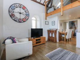 A living room with a sofa and television at Eglwys St Cynfil in Penrhos near Pwllheli