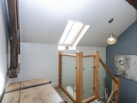 A landing area with a wooden chest and artwork at Eglwys St Cynfil Penrhos near Pwllheli