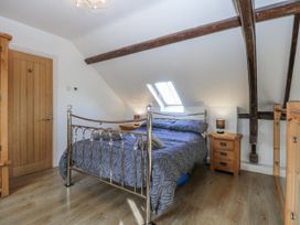 A bedroom with a bed and wooden furniture at Eglwys St Cynfil Penrhos near Pwllheli