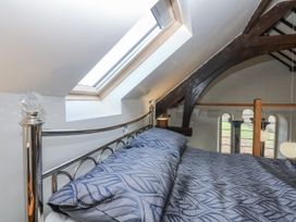 A bedroom with a bed and a window at Eglwys St Cynfil in Penrhos near Pwllheli