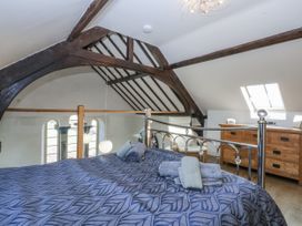 A bedroom with a bed and dresser at Eglwys St Cynfil Penrhos near Pwllheli