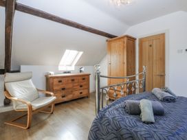 A bedroom with a bed and chest of drawers at Eglwys St Cynfil Penrhos near Pwllheli