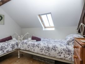 A bedroom with two beds and a window at Eglwys St Cynfil in Penrhos near Pwllheli