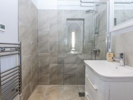 A bathroom with a shower and washbasin at Eglwys St Cynfil Penrhos near Pwllheli