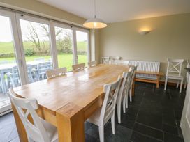 A dining room with a large table and chairs at Chapel House Elim near Llanddeusant