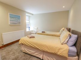 A bedroom with two single beds and a chair at Chapel House Elim near Llanddeusant