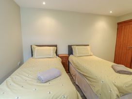 A bedroom with two beds and a nightstand at Chapel House Elim near Llanddeusant