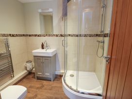 A bathroom with a shower, sink, and towel radiator at Chapel House Elim near Llanddeusant