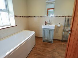 A bathroom with a bathtub and sink at Chapel House Elim near Llanddeusant