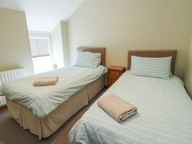 A bedroom with two single beds and a bedside table at Chapel House Elim near Llanddeusant