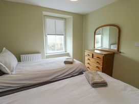 A bedroom with two beds and a dresser at Chapel House Elim near Llanddeusant