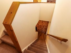 A staircase with wooden handrail and wall at The Old Bothy Bolton Low Houses near Wigton