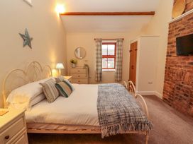 A bedroom with a bed and dresser at The Old Bothy Bolton Low Houses near Wigton