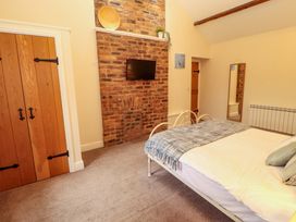 A bedroom with a bed and a wardrobe at The Old Bothy Bolton Low Houses near Wigton