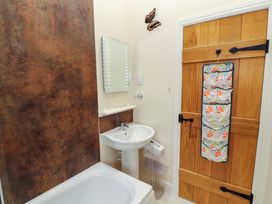 A bathroom with a bathtub, sink and mirror at The Old Bothy Bolton Low Houses near Wigton