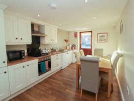 A kitchen with appliances and a dining table at The Old Grainstore Bolton Low Houses near Wigton