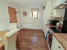 A kitchen with dining table and appliances at The Old Grainstore Bolton Low Houses near Wigton