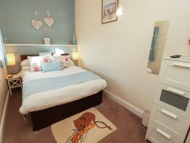 A bedroom with a bed and nightstand at The Old Grainstore Bolton Low Houses near Wigton