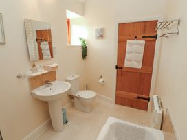 A bathroom featuring a sink, toilet, and bathtub at The Old Grainstore Bolton Low Houses near Wigton