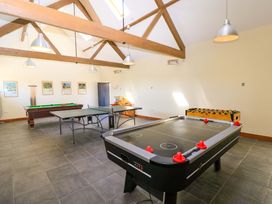 A game room with an air hockey table ping pong table pool table and foosball table at The Old Stables in Winterborne Stickland