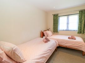 A bedroom with two single beds at Corner Barn in Winterborne Stickland