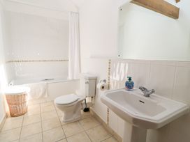 A bathroom with a bathtub, toilet, and sink at Corner Barn Winterborne Stickland