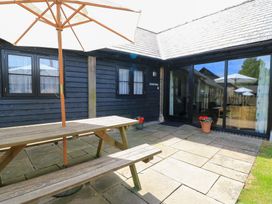 An outdoor seating area with a table and umbrella at Corner Barn Winterborne Stickland
