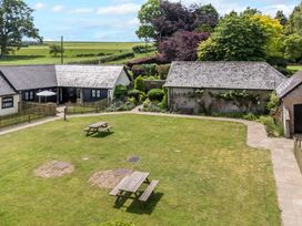 An outdoor area with a garden and tables at Corner Barn in Winterborne Stickland