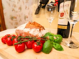 A kitchen with bread, tomatoes, basil, wine and glasses at Dilston House in Goathland