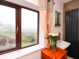 A bathroom featuring a window, flowers in a vase, and a sink at Dilston House in Goathland