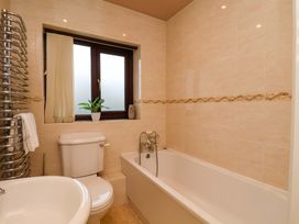 A bathroom with a bathtub, toilet, and sink at Dilston House in Goathland