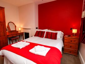 A bedroom with a bed and a dressing table at Dilston House in Goathland