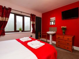 A bedroom with a bed and television at Dilston House in Goathland