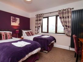 A bedroom with two beds and a desk at Dilston House in Goathland