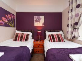 A bedroom with two single beds and wall art at Dilston House in Goathland