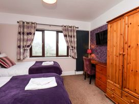 A bedroom with two beds and a window at Dilston House in Goathland